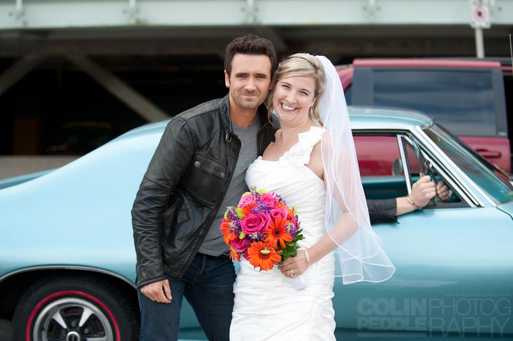 In a spur of the moment photograph a bride poses with an actor from Republic of Doyle for a wedding photo