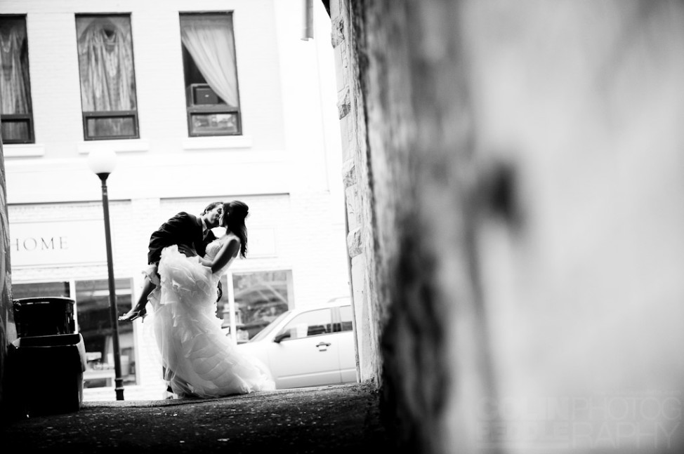 In a downtown ally of St. John's, Newfoundland a newlywed couple kisses on their wedding day.