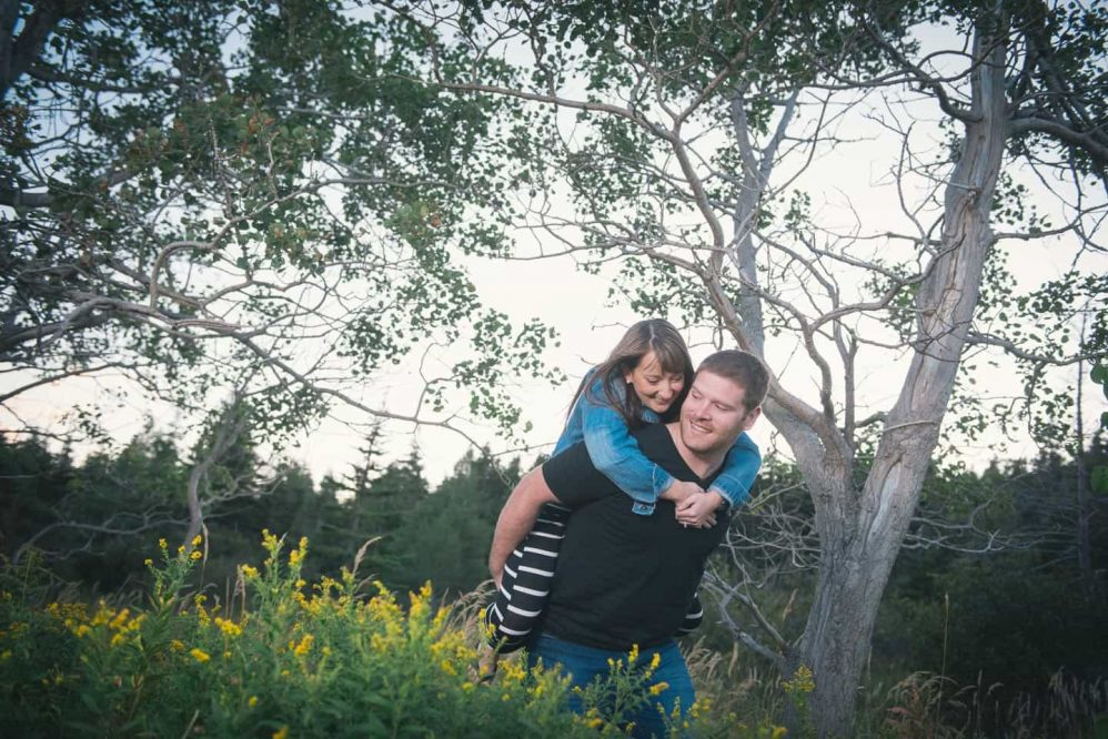 A man piggybacks his soon to be wife in this engagement session photograph.