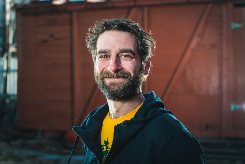 A smiling musician poses for a promotional photograph.