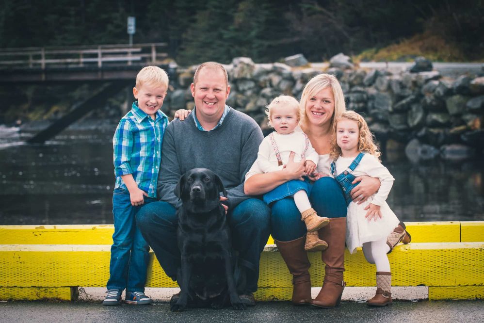 A family poses for a photography on the edge of the dock.