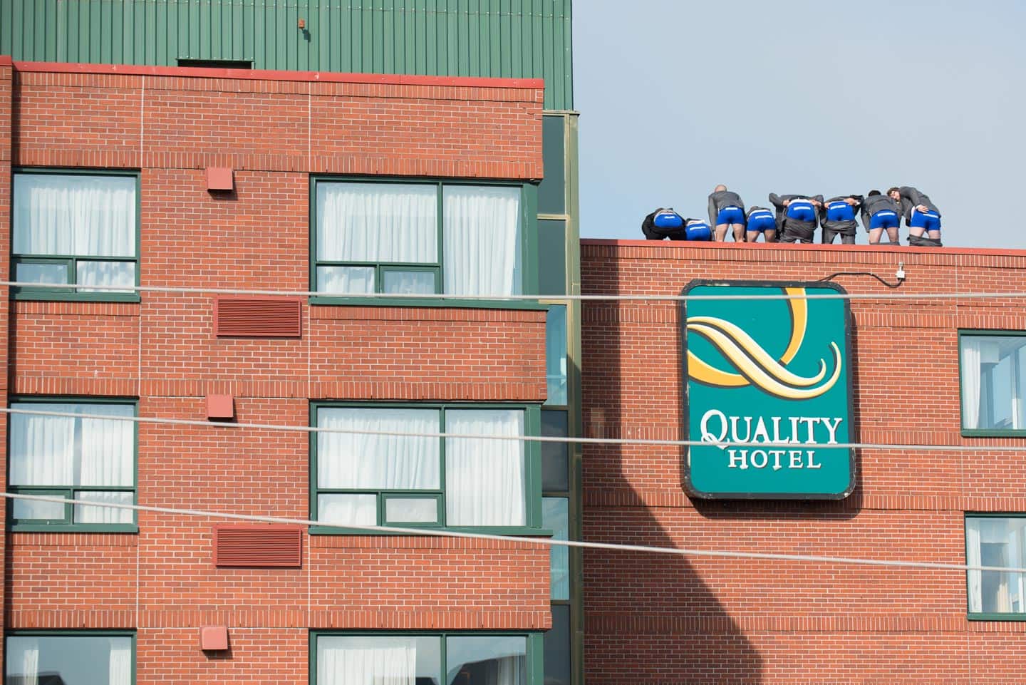 A hilarious wedding photo shows the groomsmen with their pants down mooning a city from atop a hotel.