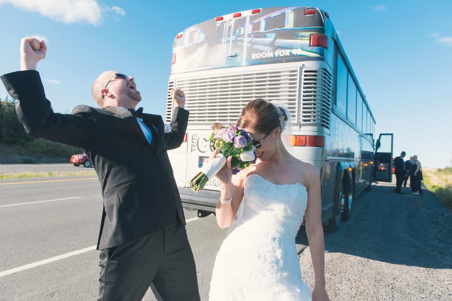 A couple waits on the side of a highway nearby a broken down bus. Planning is important on your wedding day.