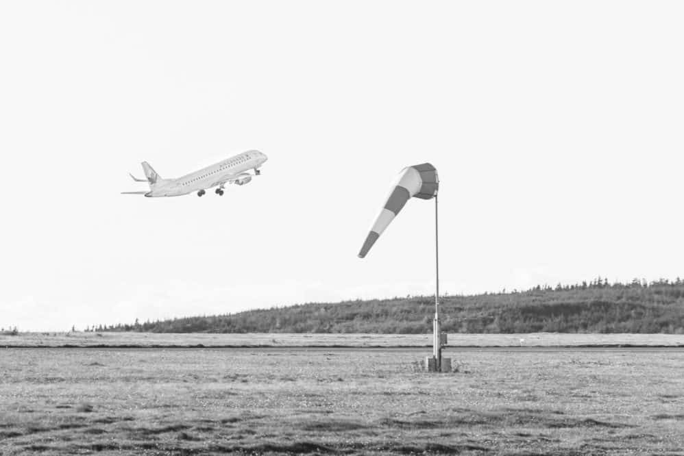Air Canada departing CYYT with a windsock in the foreground.