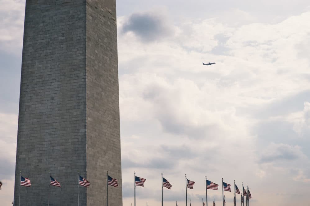 A plane departs Reagan International with the Washington Monument in the foreground.