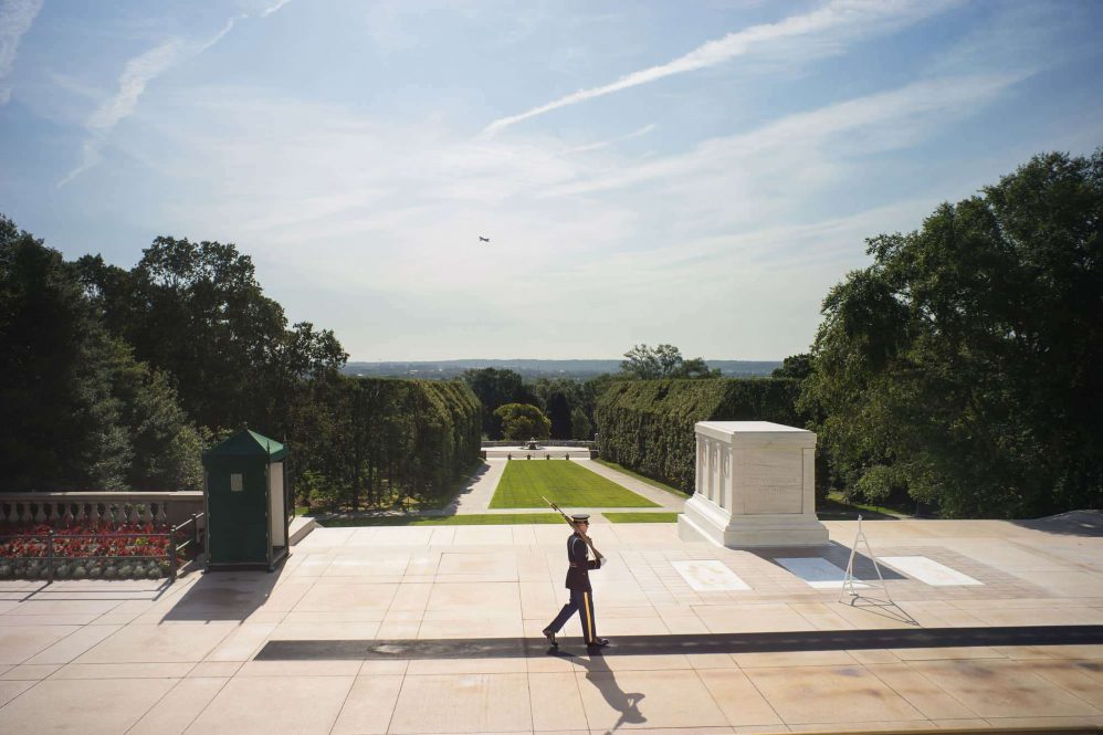 A soldier guards the tomb of the unknonwn at arlington national cemetary.