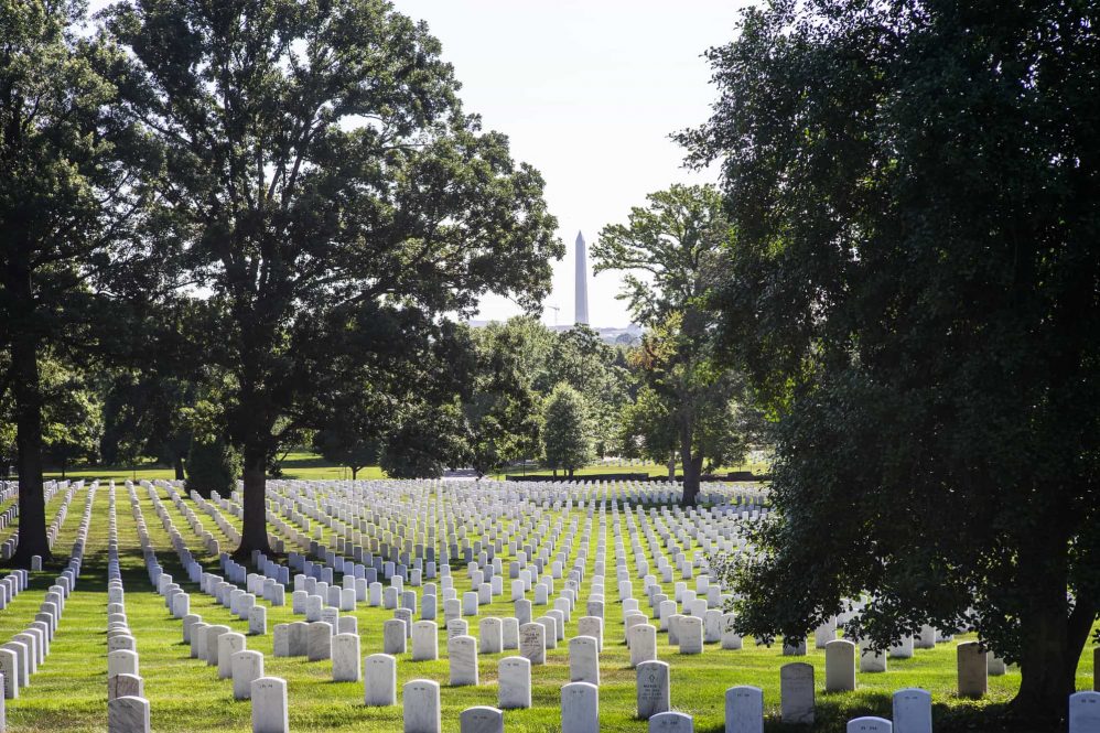 A photograph looking through the grave markers to see the Washington Monument at arlington national cemetary.