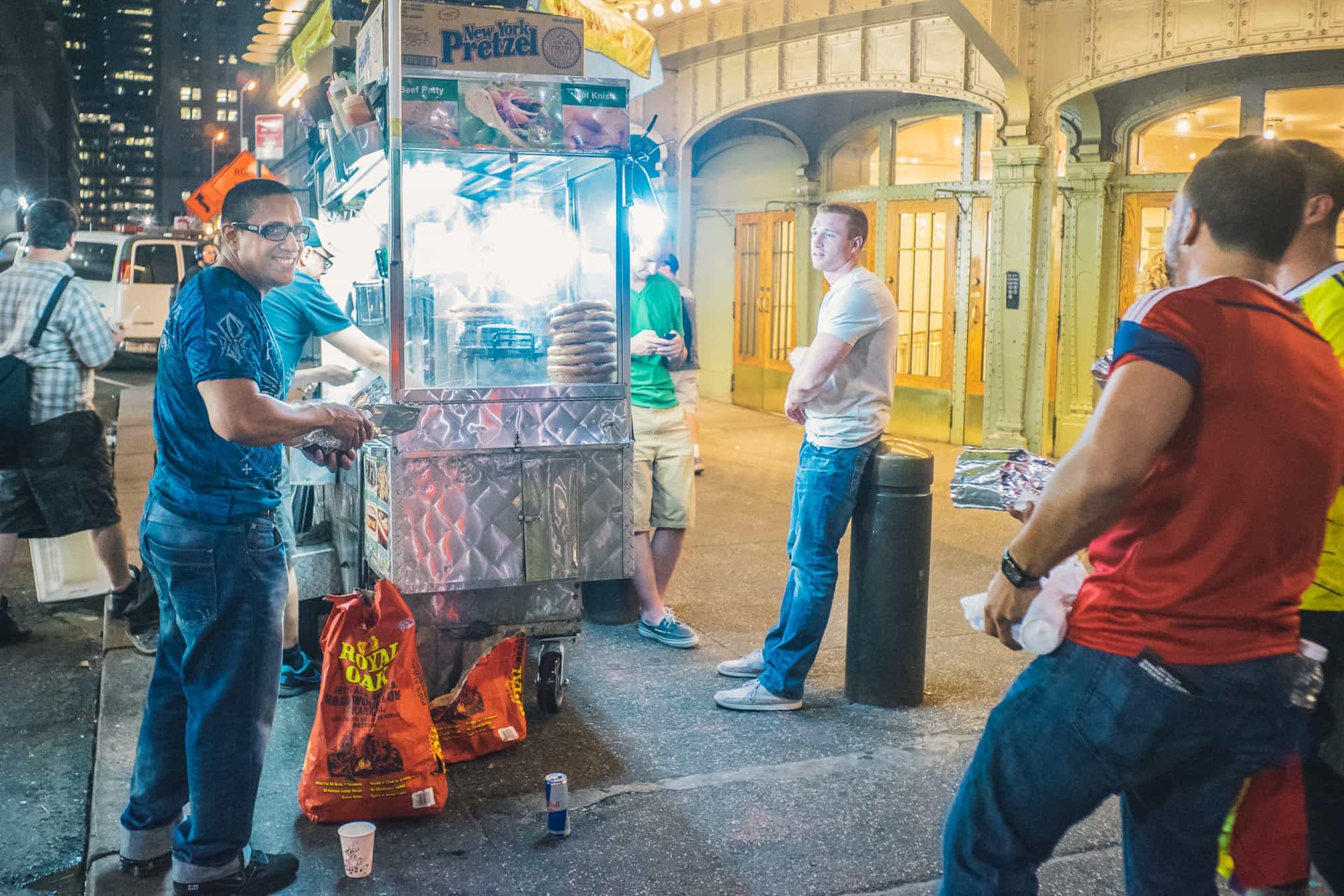 In New York City a group of guys hang out at a food cart for midnight grub after an evening on the sauce, no doubt.
