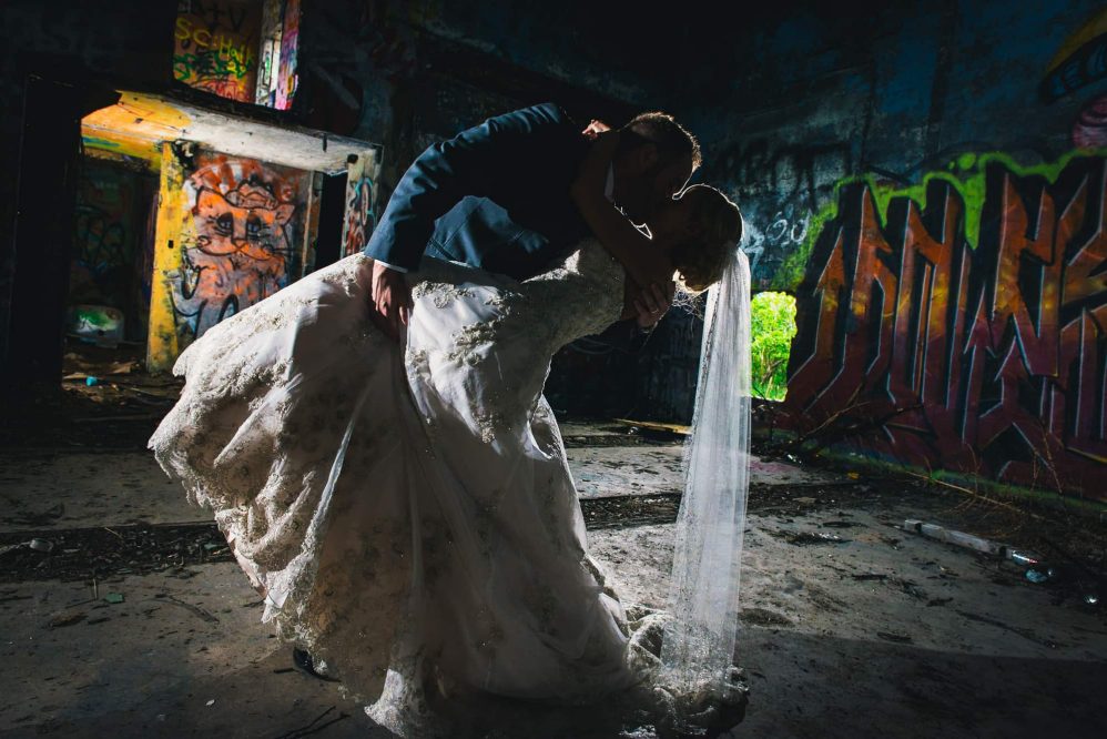 A bride and groom grab a kiss silhouetted aginst the backdrop of an old radar station.