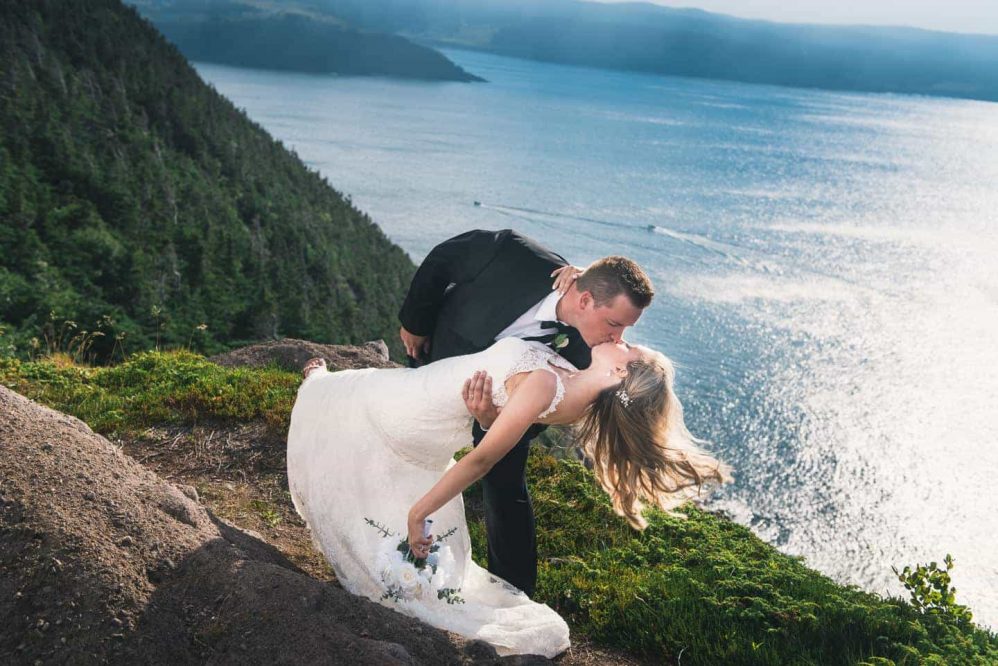 A groom dips his bride along the Newfoundland coastline.