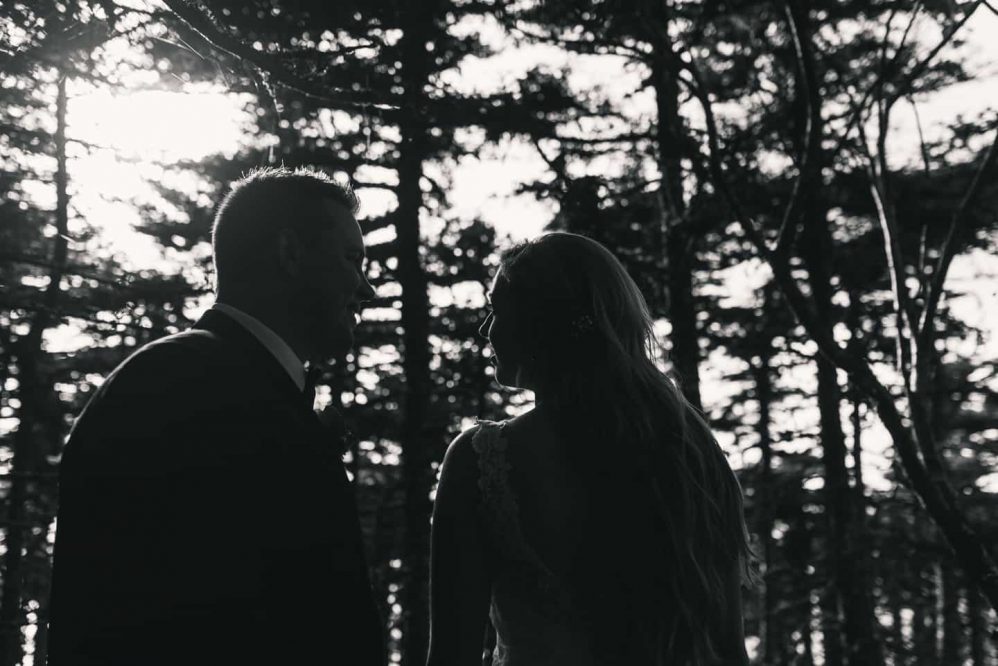 A bride and groom lovingly gaze into each others eyes in this delightful black and white photograph.