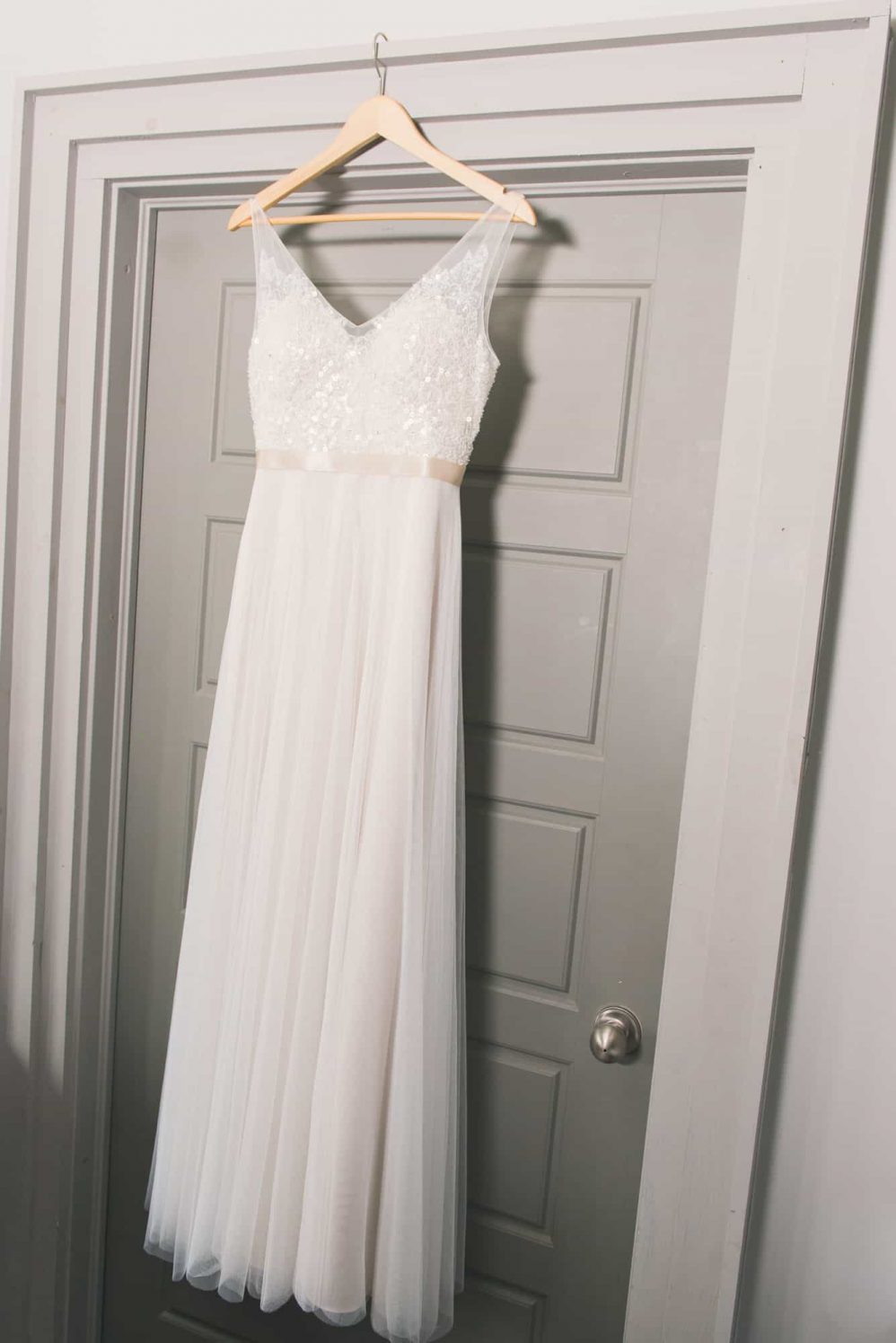 A brides wedding dress hangs prior to being worn for the wedding day.