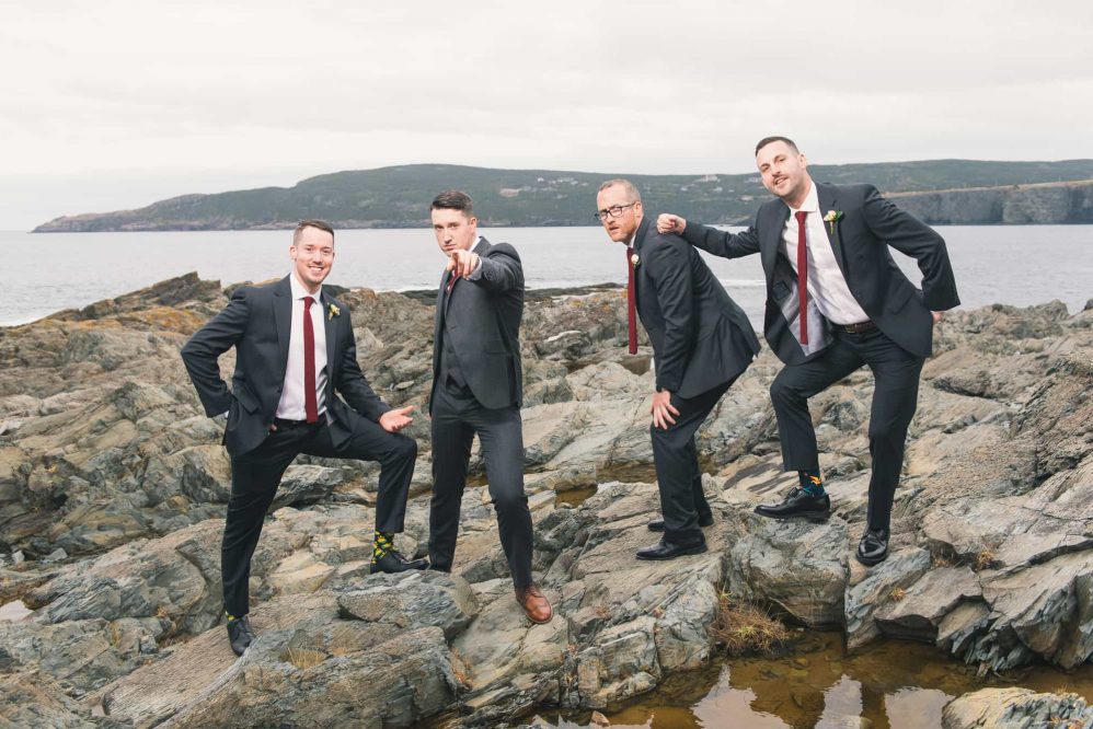 A group of groomsmen sarcastically pose for photographs like a early 2000s boy band