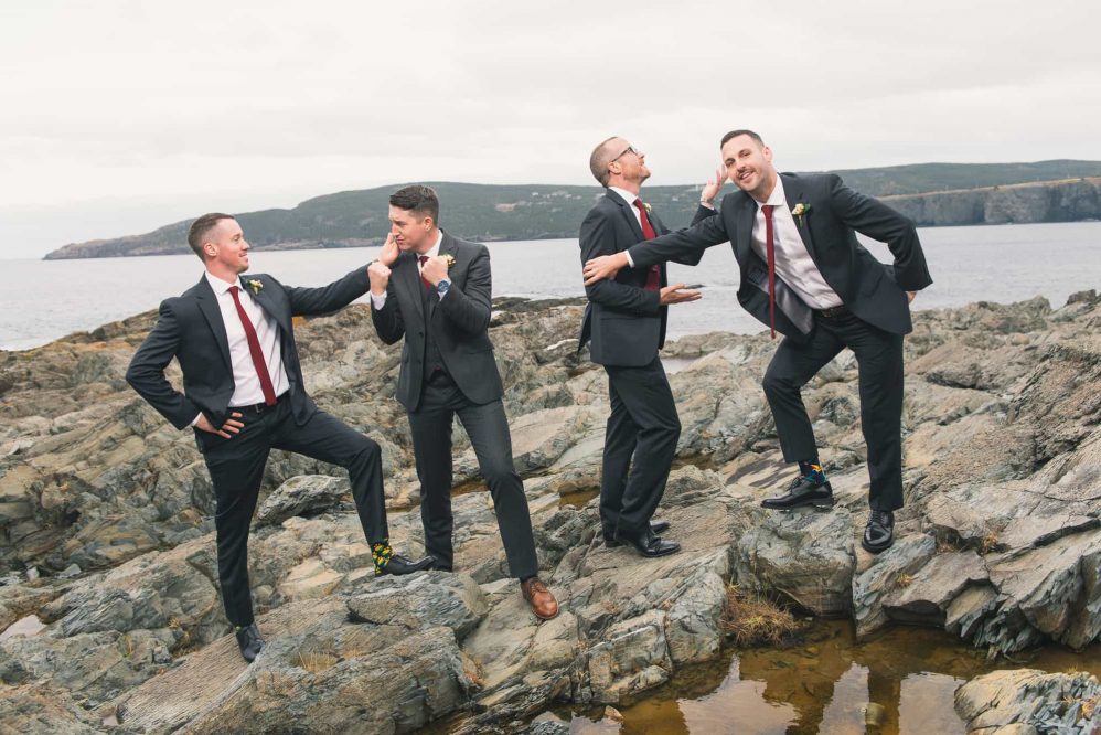 A group of groomsmen sarcastically pose for photographs like a early 2000s boy band