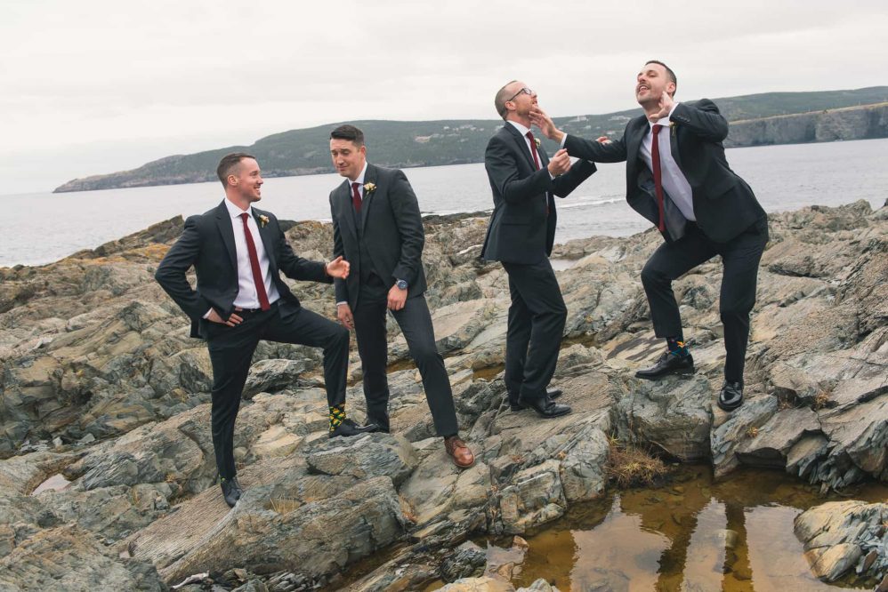 A group of groomsmen sarcastically pose for photographs like a early 2000s boy band