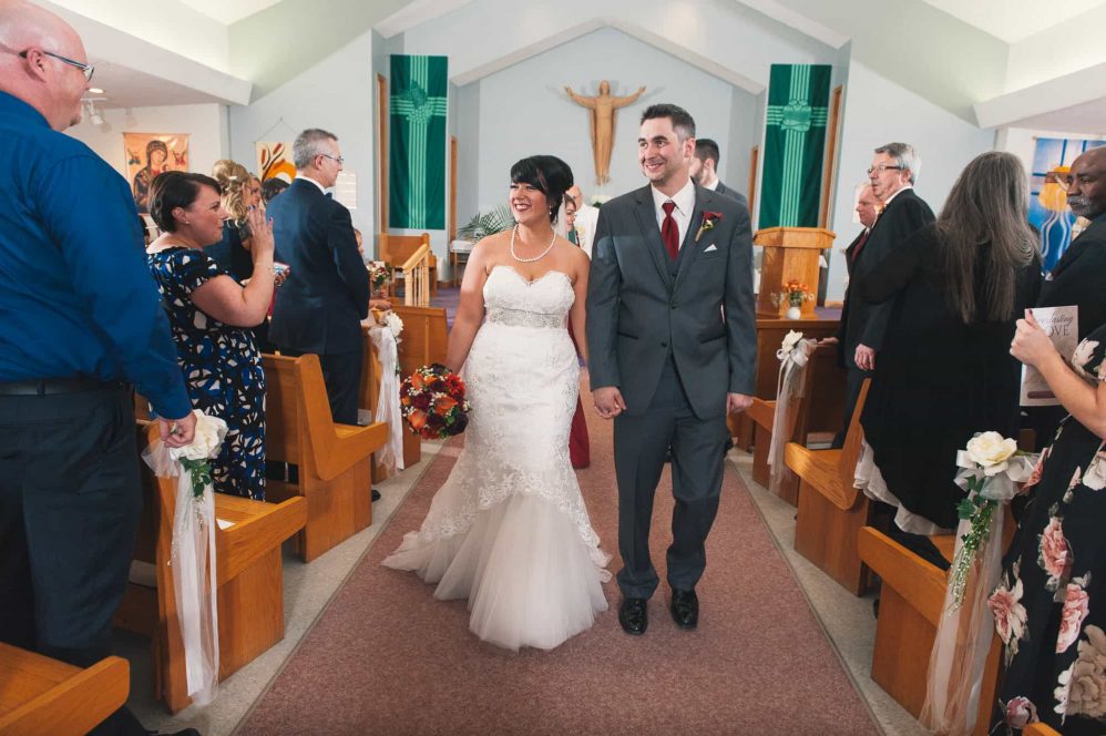 A newly married couple walk down the aisle.