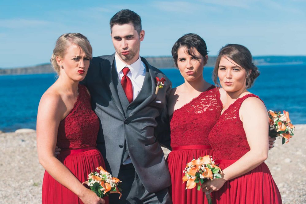 The groom and the bridesmaids post for a funny photograph.