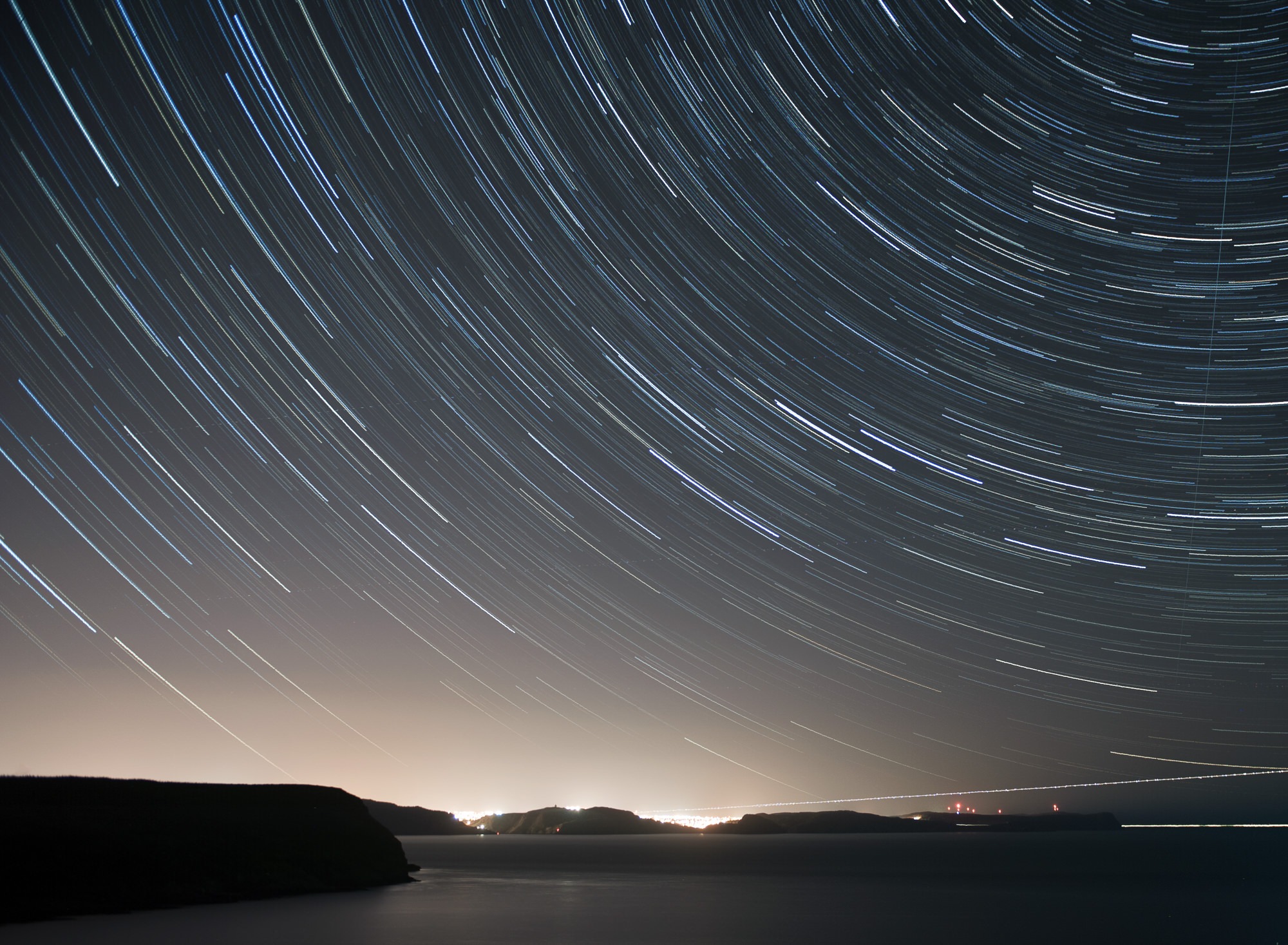 This image is made from 95 images, each 30 seconds in length at f/2.8 ISO200. Body: Nikon D3 and 24-70 lens, cropped to 8×10, shot from Cape Spear, Newfoundland This is an image that I’ve had in mind for a while but hadn’t actually remembered to go shoot. The trick with this is that you can’t just open the shutter for a long period of time, ie: 30 minutes. If you were to do that, the light pollution from the city would eventually over power the stars and you’d have nothing but a glow of city light and very few stars. So how do we do this? Well to start you’re going to need either a body capable of interval shooting or a cable release with a shutter lock. Once you’ve got one of those, you’re going to need to shoot a LOT of images, all at the same settings, over the course of 20-30minutes (or longer really, longer the better). Once you’ve got your 100 or so images, each a long exposure, you’ll be combining them in Photoshop to form one image, like the one below. In this photo you can see the stars which make up the big dipper, planes landing at St. John’s International Airport (CYYT), a boat going out to sea, the car lights from Signal Hill, Fort Amherst and the East End of St. John’s.