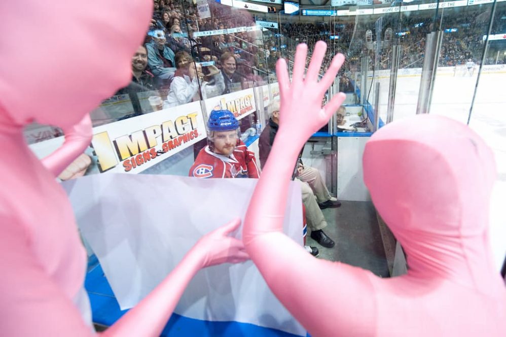 Tom Fitzgerlad of the Hamilton Bulldogs is harrassed by men dressed in tight body suits.