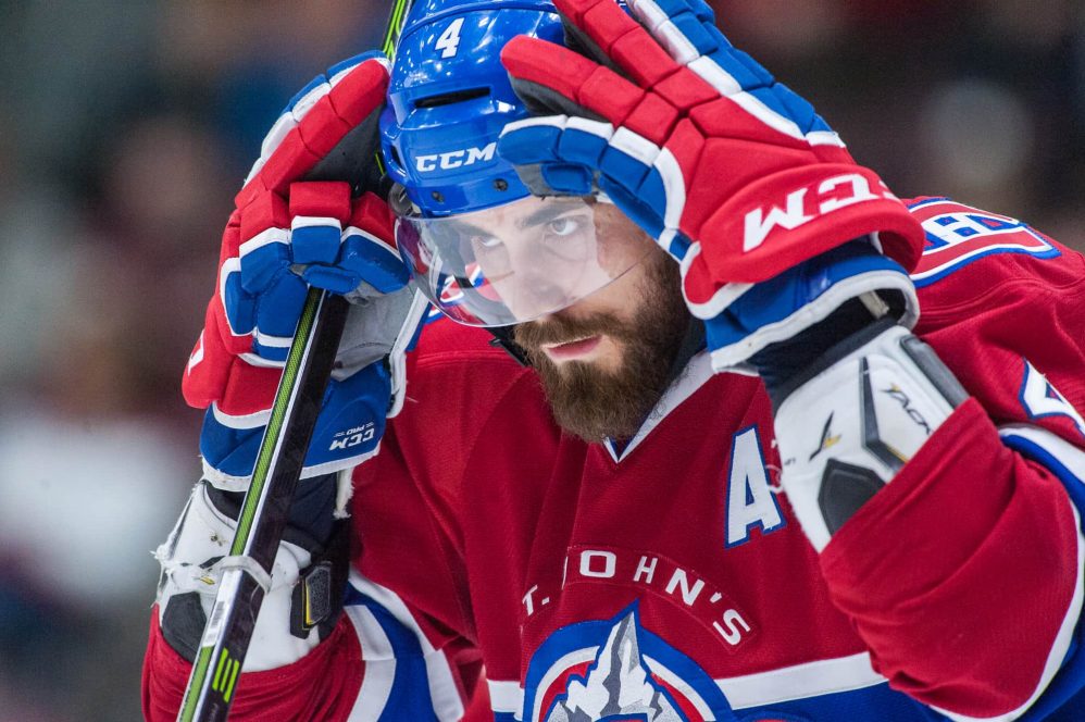 IceCaps defenseman Morgan Ellis fastens his helmet to his head during an unknown IceCaps AHL hockey game in 2016.