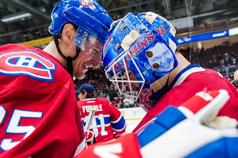 Michael McCarron and Eddie Pasquale bump helmets during a post game celebration.